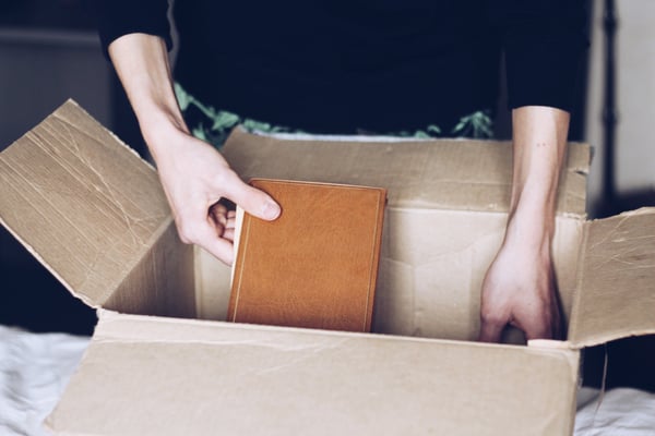 woman packing a book into a moving box